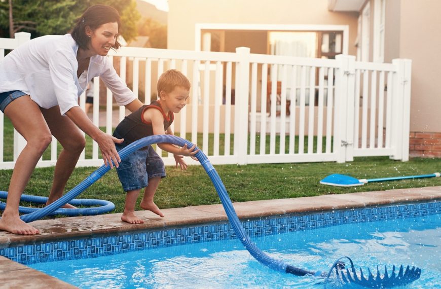 Fun times by the pool. Shot of a mother and son cleaning the pool together