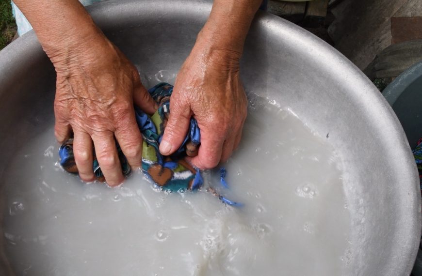 Elderly grandma hand washing clothes