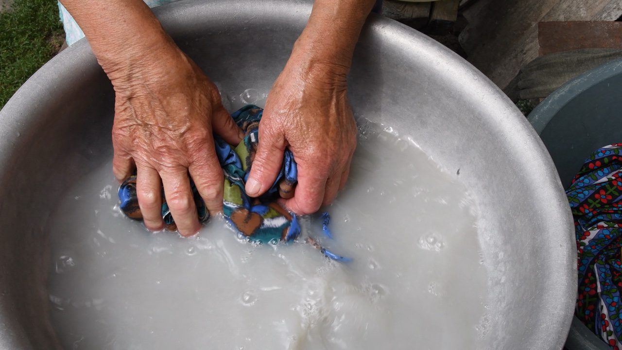 Elderly grandma hand washing clothes