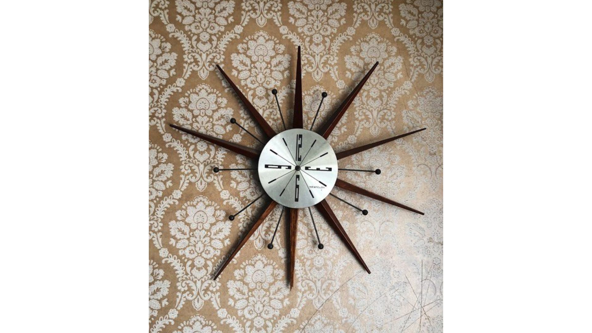 Vintage midcentury-modern starburst wall clock by Westclox, silver color with wood. Looks like 1960s.

