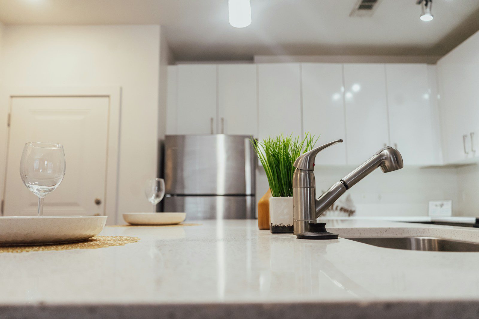 a kitchen counter with a sink and a wine glass