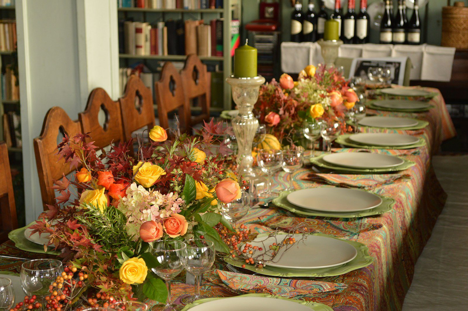 A long table is set with plates and flowers