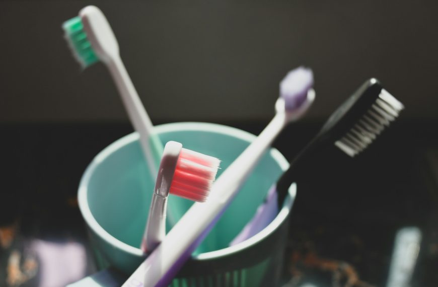 two toothbrushes in a cup with toothpaste
