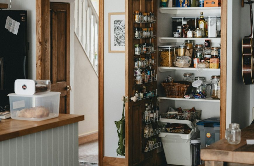 white plastic trash bin beside brown wooden shelf
