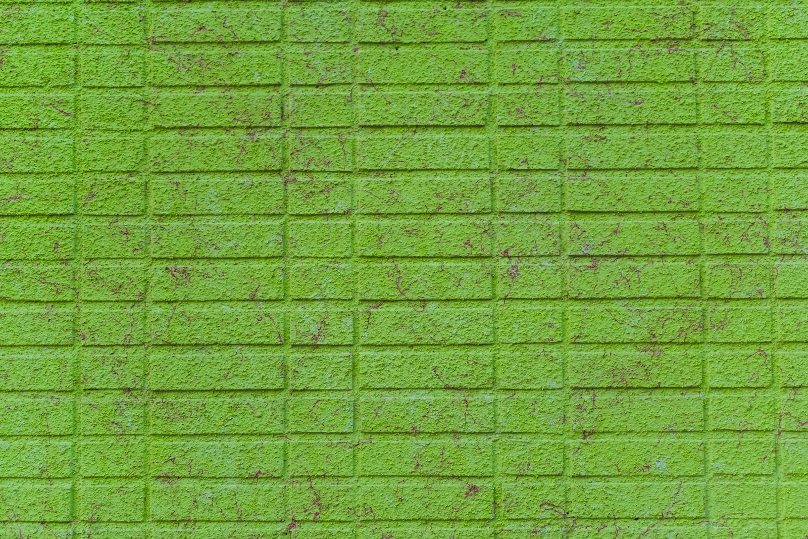 a green brick wall that has been painted green