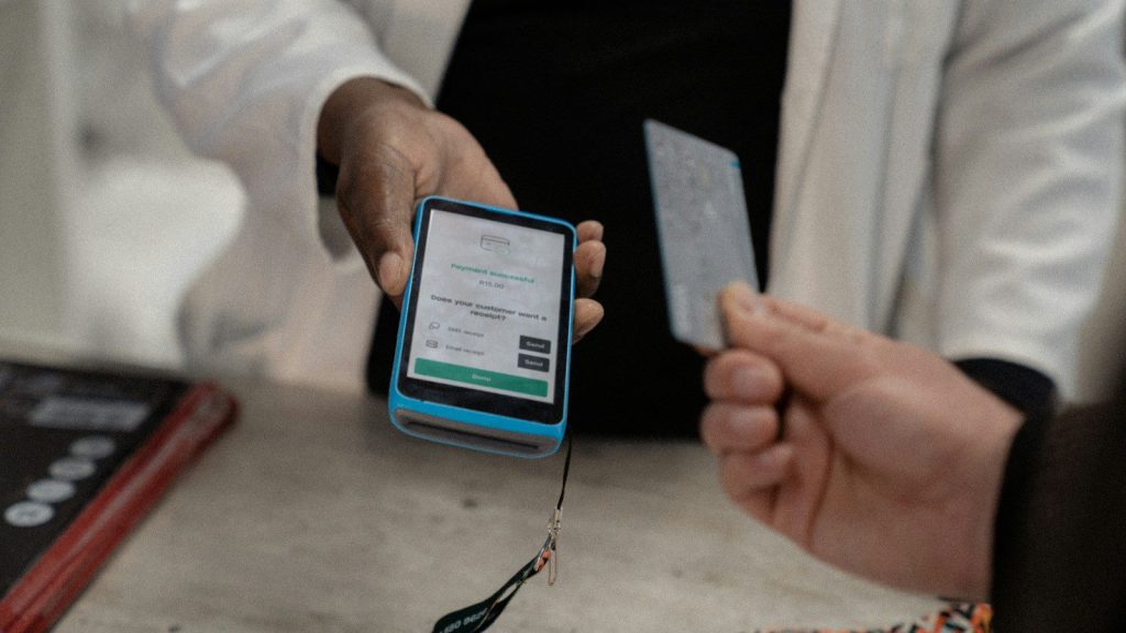 a person holding a smart phone and a credit card