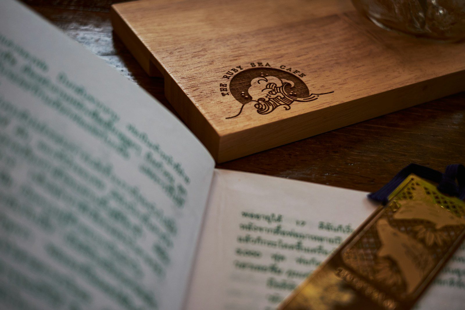 an open book on a table next to a glass