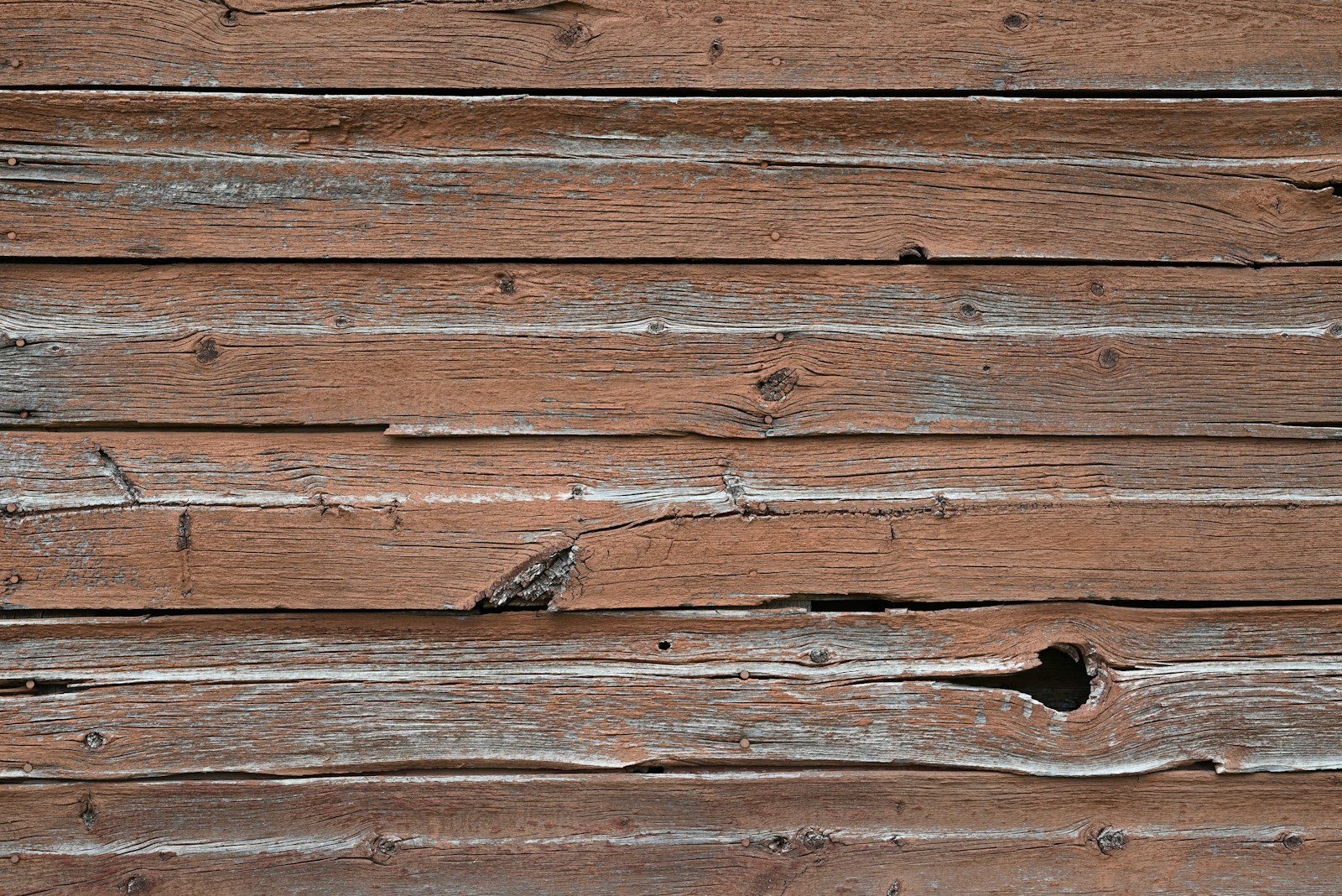 a close up of a wooden wall with peeling paint