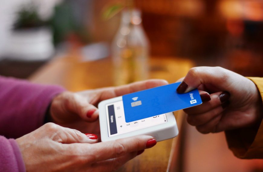 a person holding a credit card and a cell phone