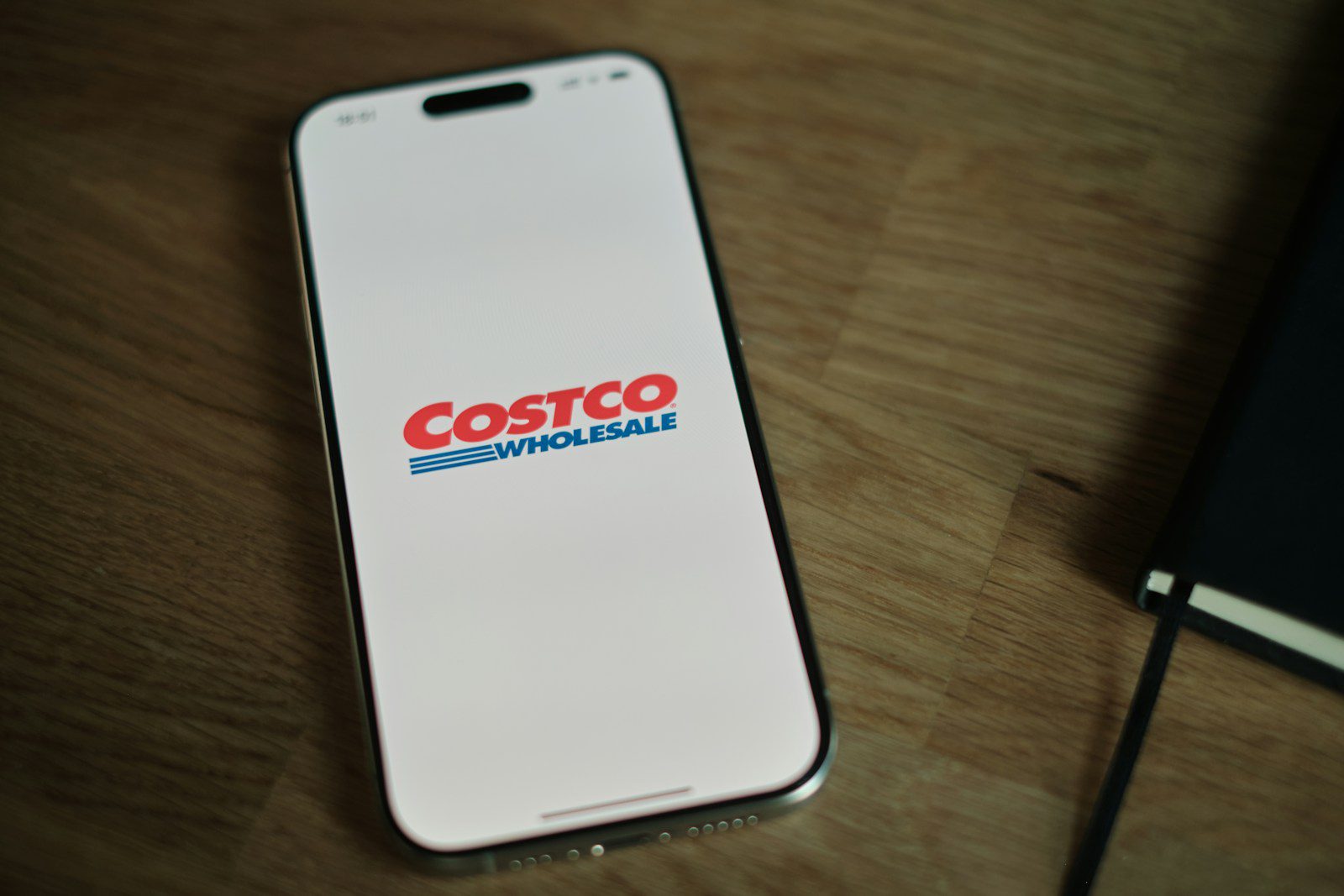 A white cell phone sitting on top of a wooden table