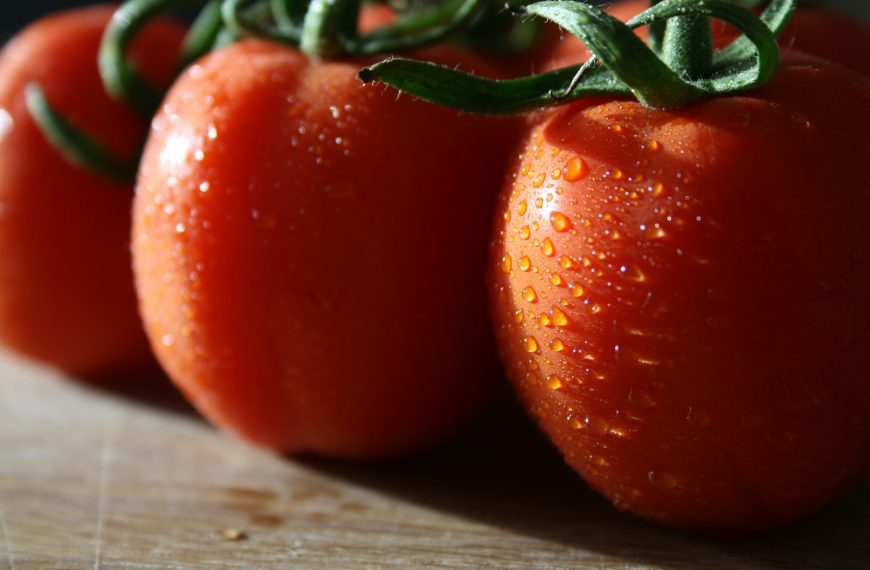 A group of tomatoes sitting on top of a wooden table