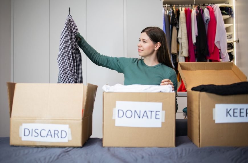 Woman decluttering stuff at home. different cartons to donate,discard and keep