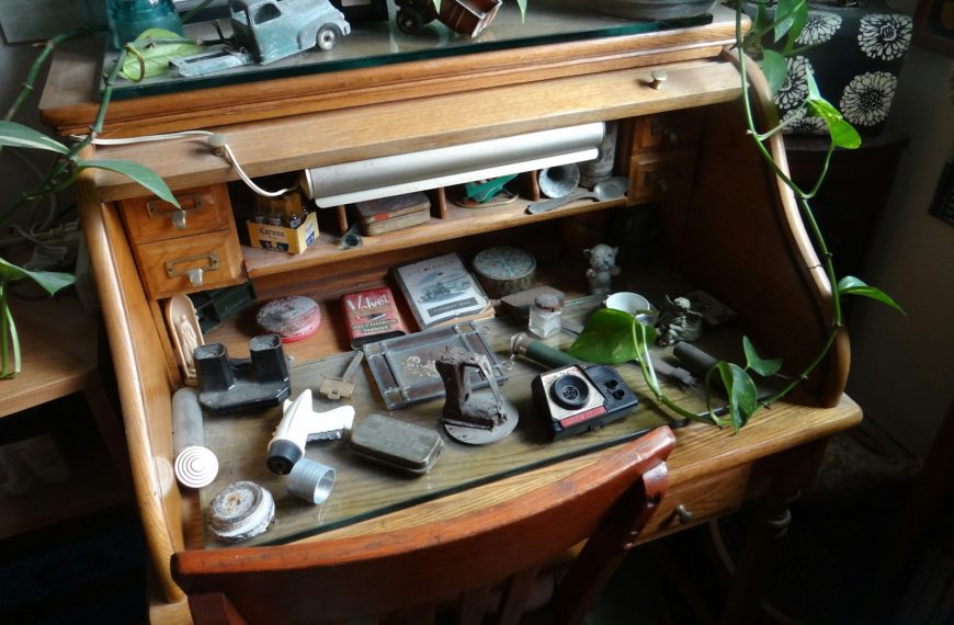 items on brown wooden roll-top desk