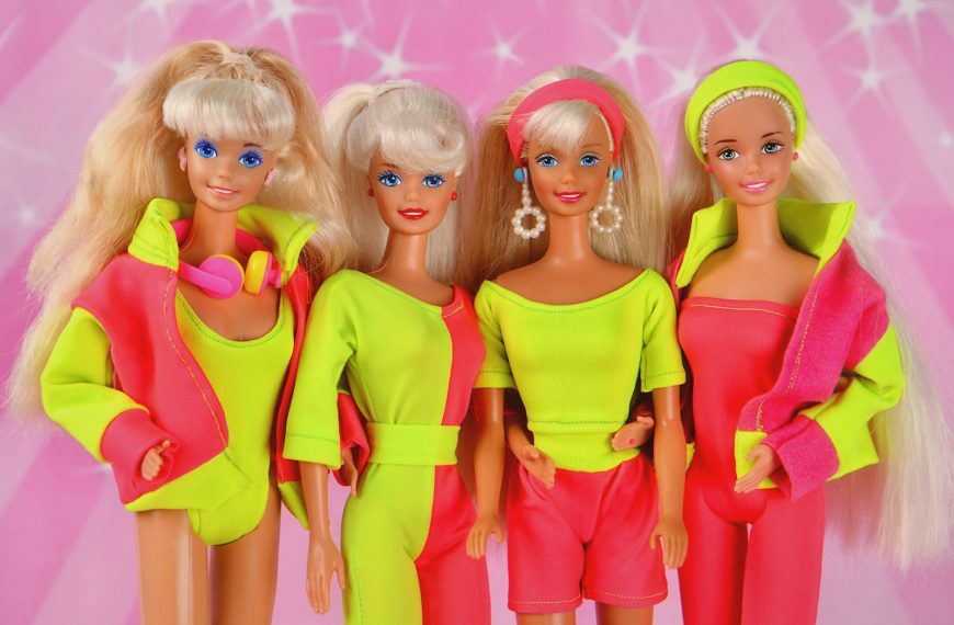 Four 80s barbie dolls posing together.