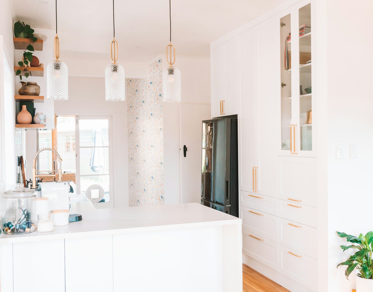 a kitchen with white cabinets and a black refrigerator