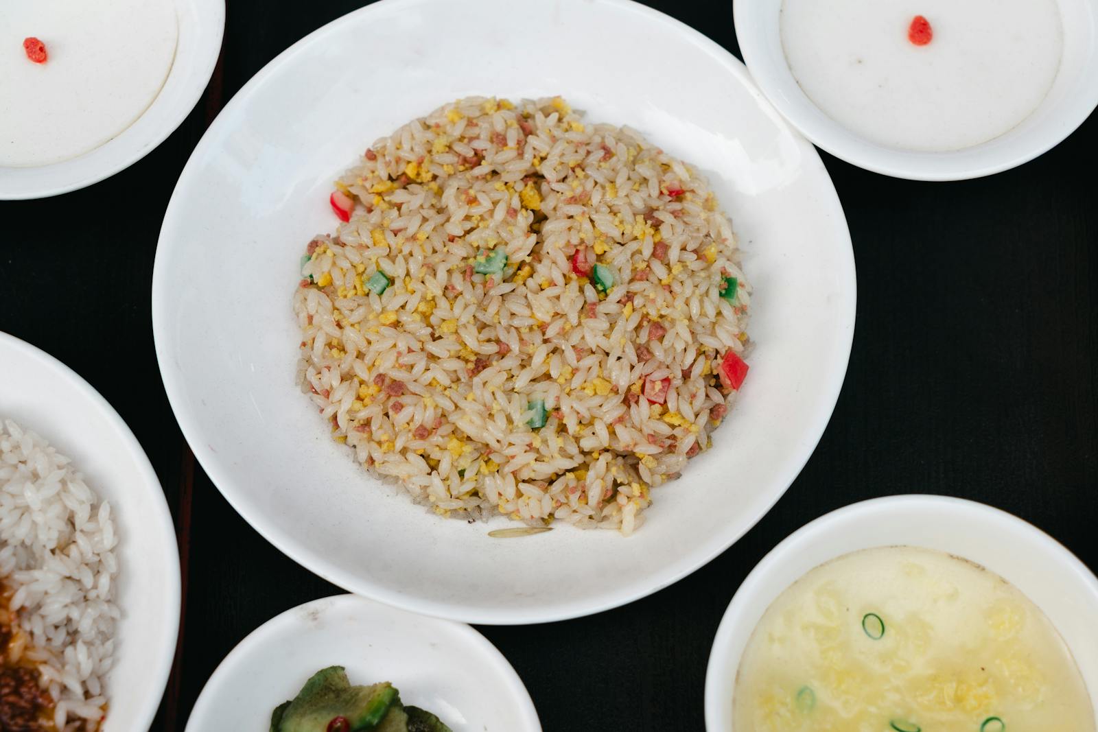 Tasty Asian fried rice served with multiple side dishes, captured in a classic flat lay.