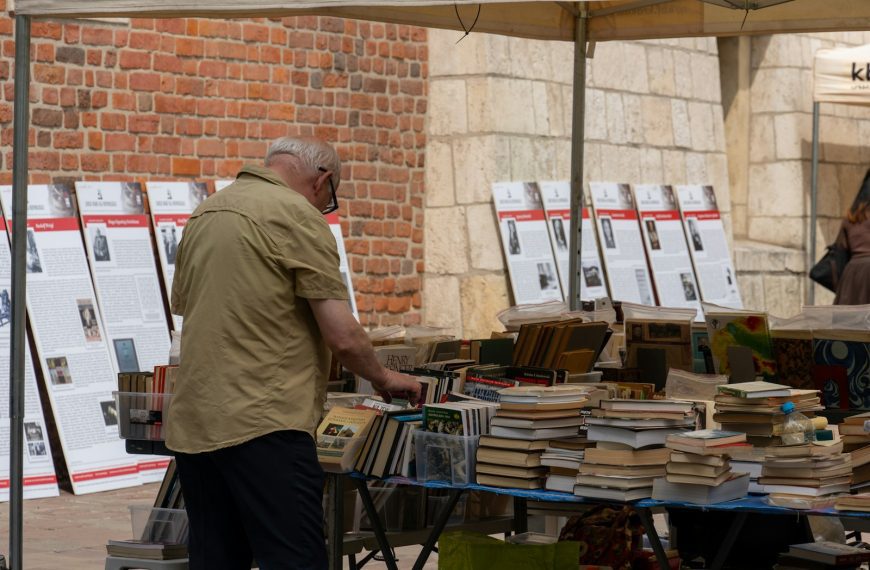 A man standing next to a table full of books