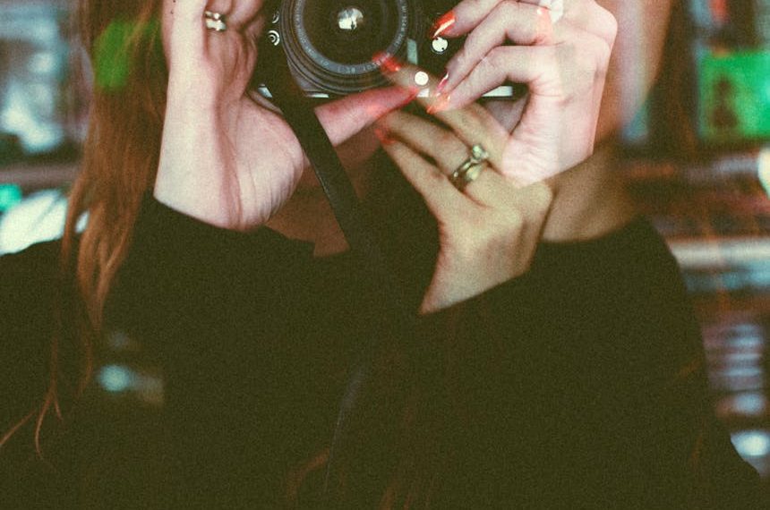 Artistic double exposure of a woman taking a photograph with vintage effects.