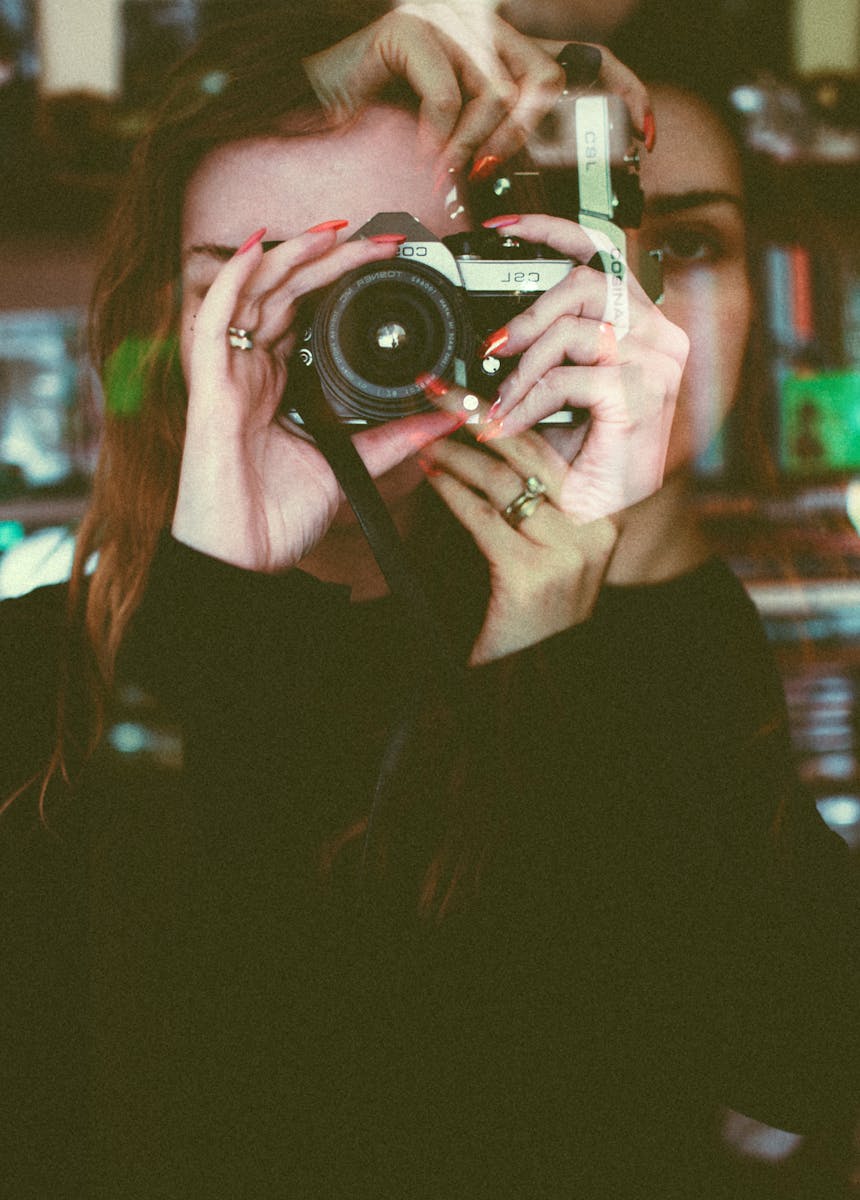 Artistic double exposure of a woman taking a photograph with vintage effects.