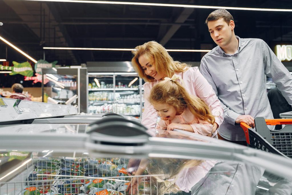A family enjoying time together while shopping in a supermarket aisle.