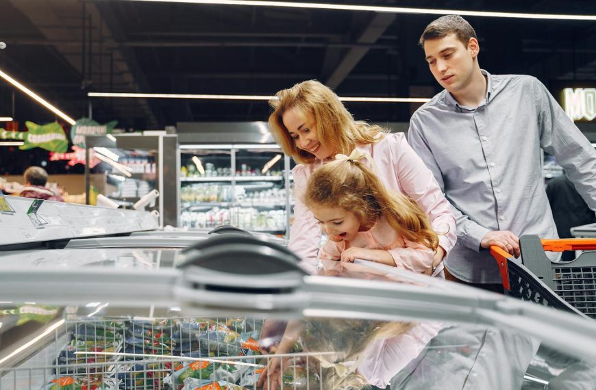 A family enjoying time together while shopping in a supermarket aisle.