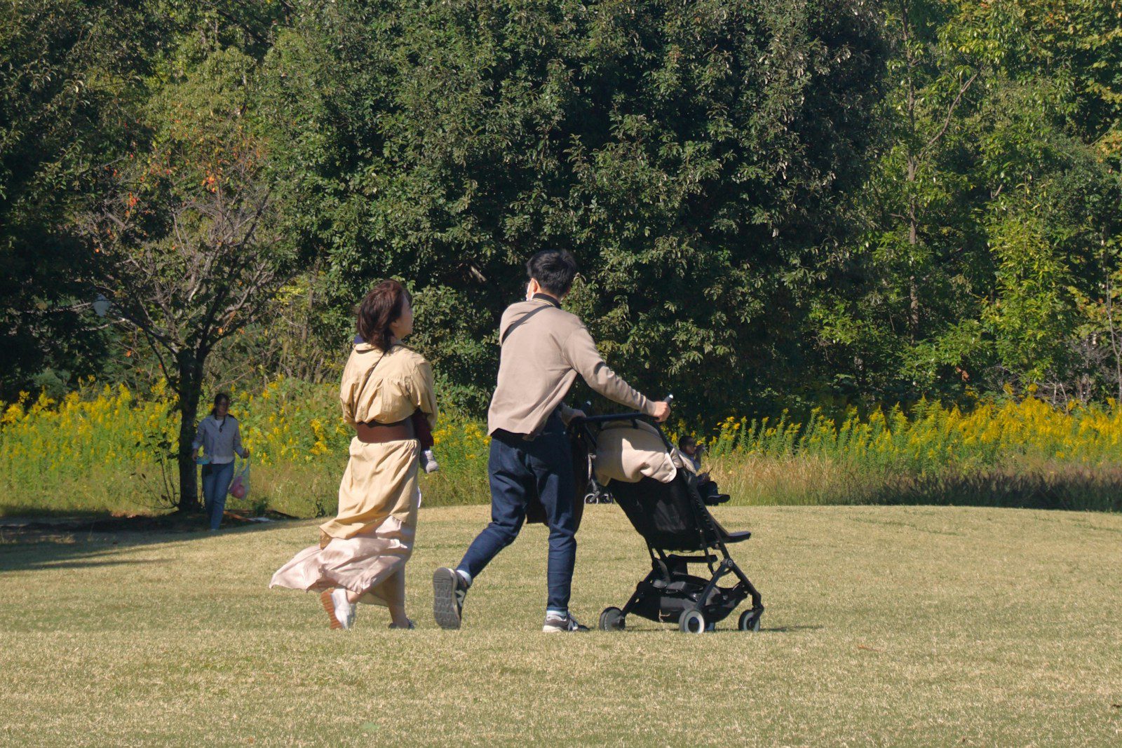 A man and a woman walking with a baby in a stroller