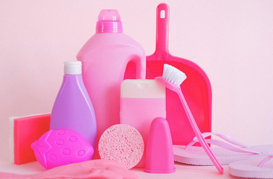 A vibrant collection of cleaning products on pink background, showcasing everyday household essentials.