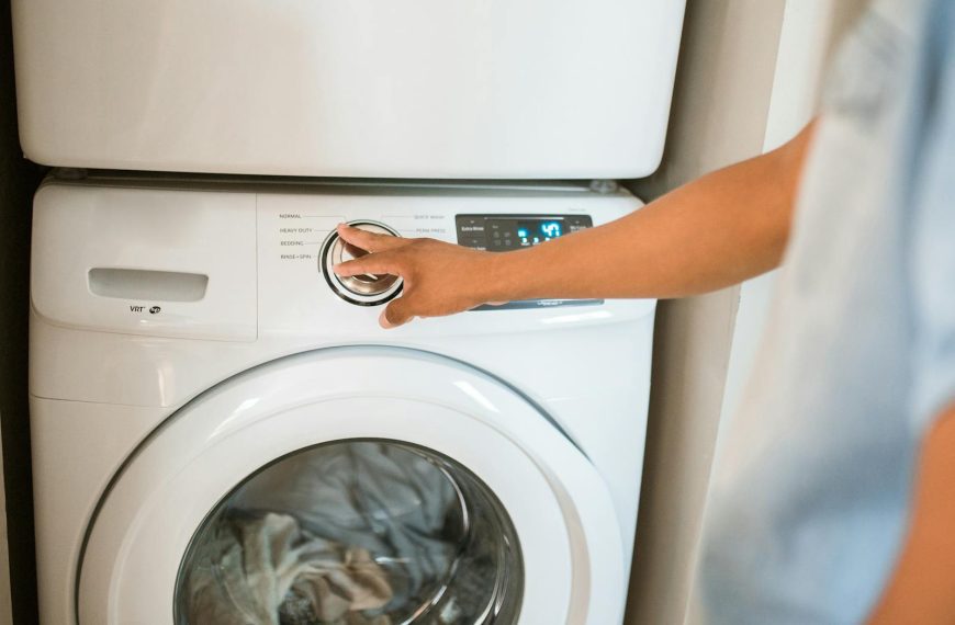 Close-up of a person adjusting a washing machine in a modern laundry room.