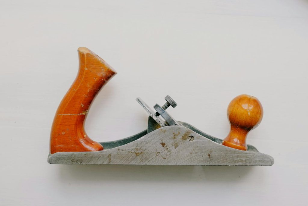 An overhead view of a vintage jack plane used for woodworking, set against a white background.