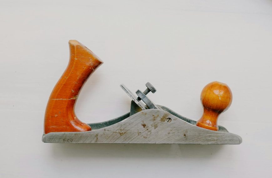 An overhead view of a vintage jack plane used for woodworking, set against a white background.