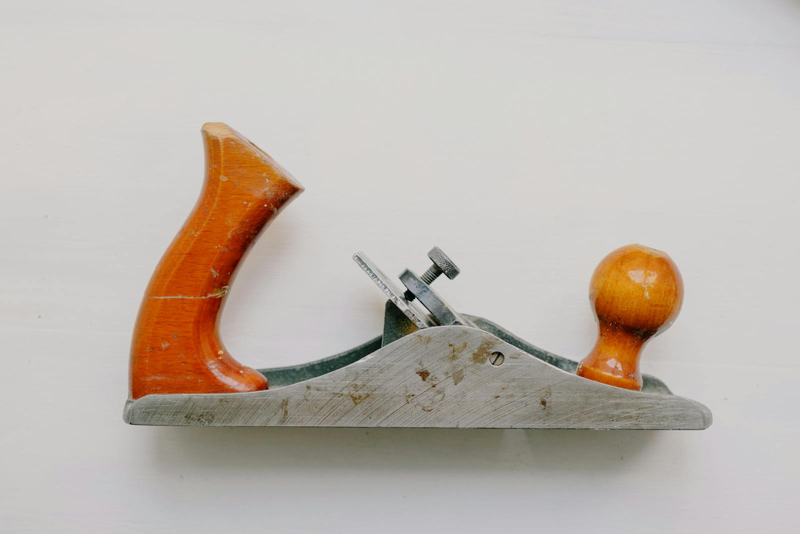 An overhead view of a vintage jack plane used for woodworking, set against a white background.