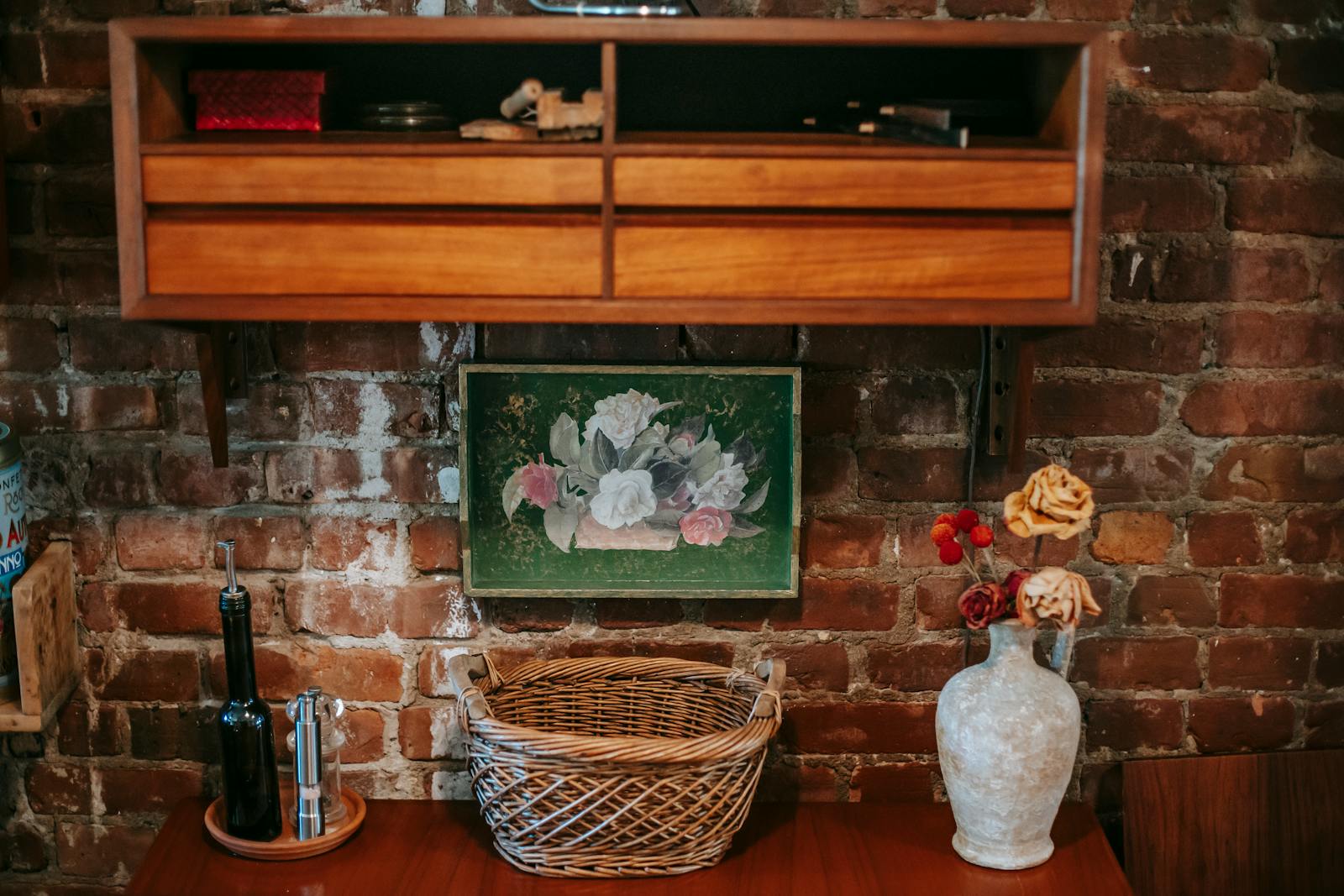 A cozy vintage interior featuring rustic decor, wooden shelves, and a brick wall.