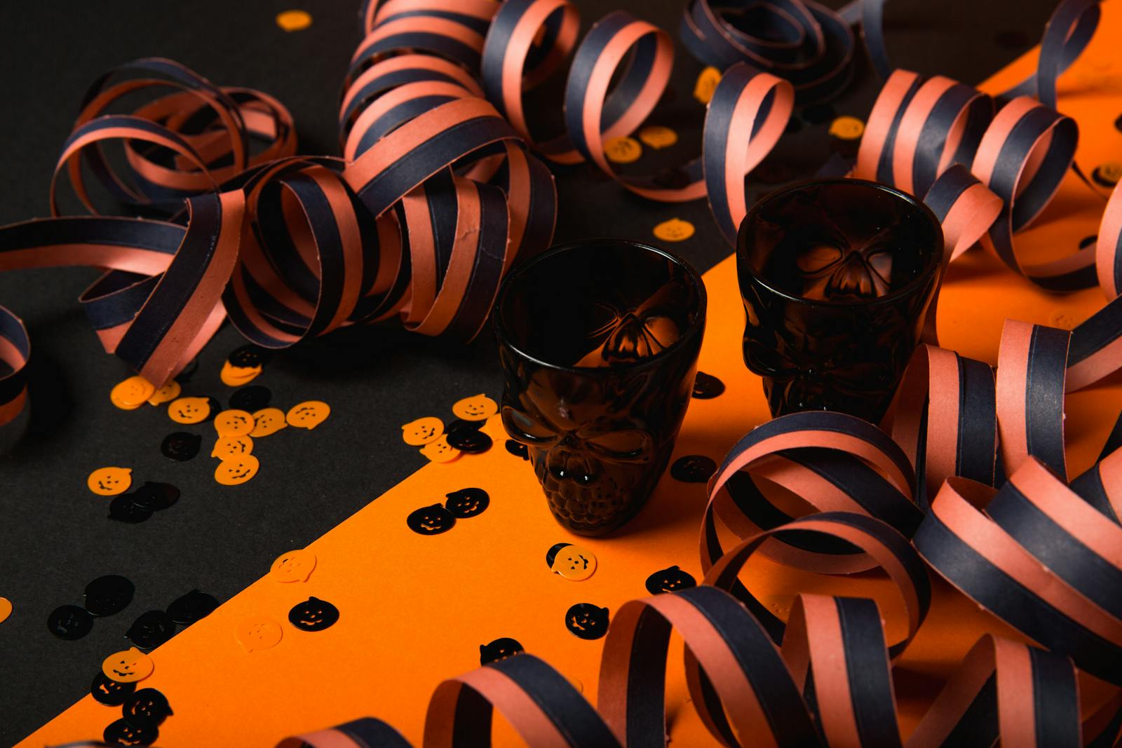 Halloween-themed decorations featuring skull shot glasses, confetti, and streamers.