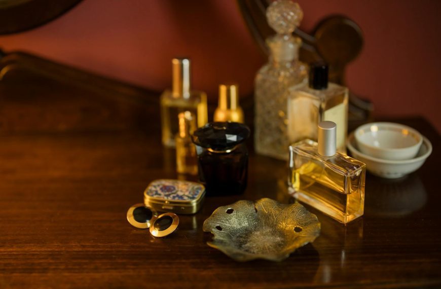 Aesthetic arrangement of perfume bottles and jewelry on a wooden vanity table, creating a vintage ambiance.