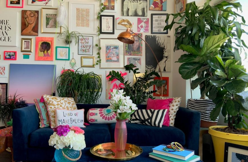 a living room with a blue couch and a vase with flowers