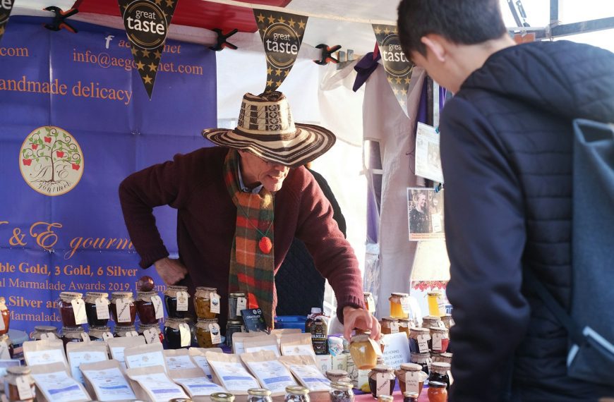a man wearing a sombrero standing next to a table filled with jars of