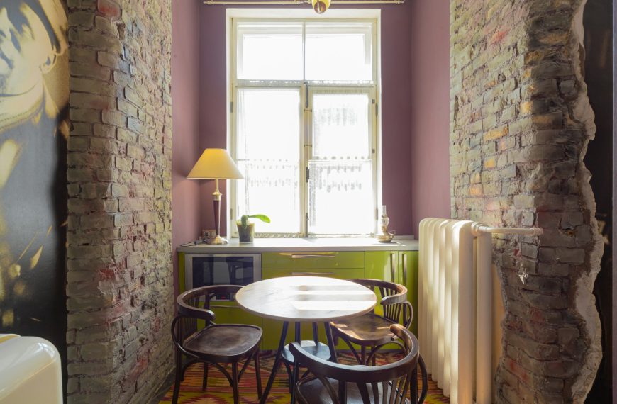 A room with a brick wall and a painting on the wall