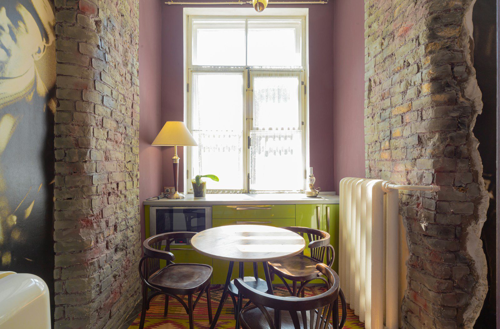 A room with a brick wall and a painting on the wall