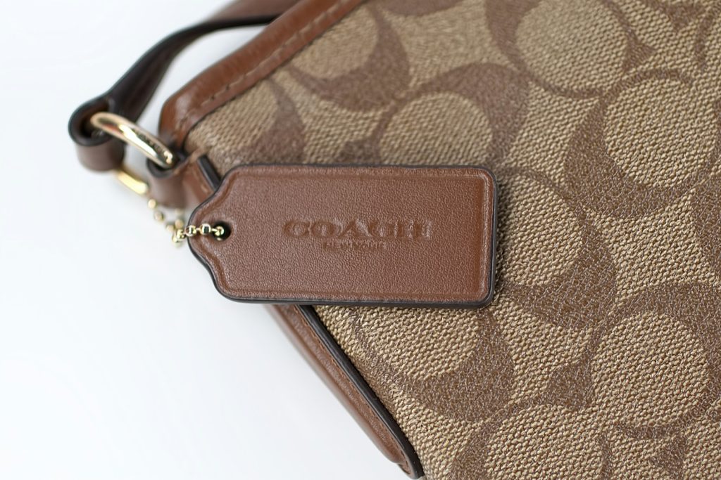 a close up of a brown coach purse