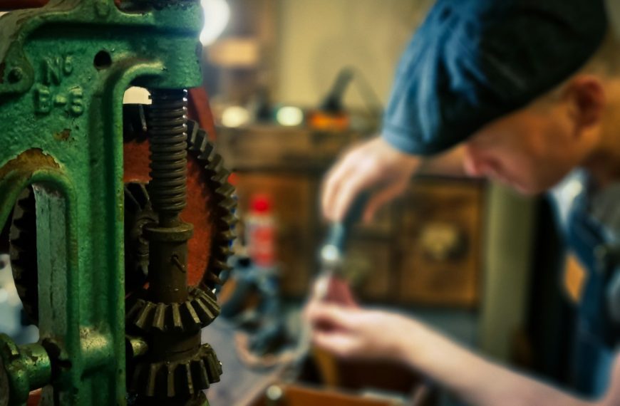 person in blue shirt holding green and silver power tool