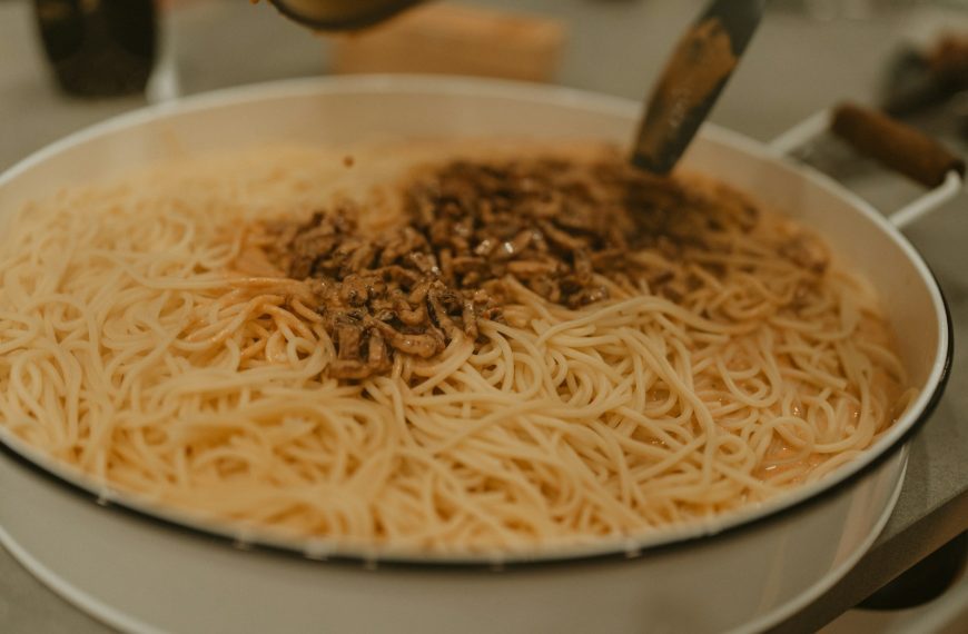 A bowl of noodles with a spoon in it