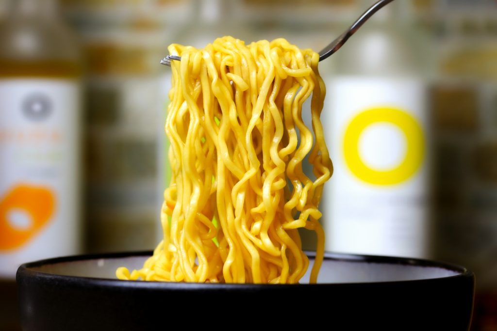 a close up of a bowl of noodles with a fork in it