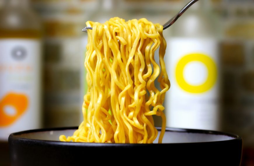 a close up of a bowl of noodles with a fork in it