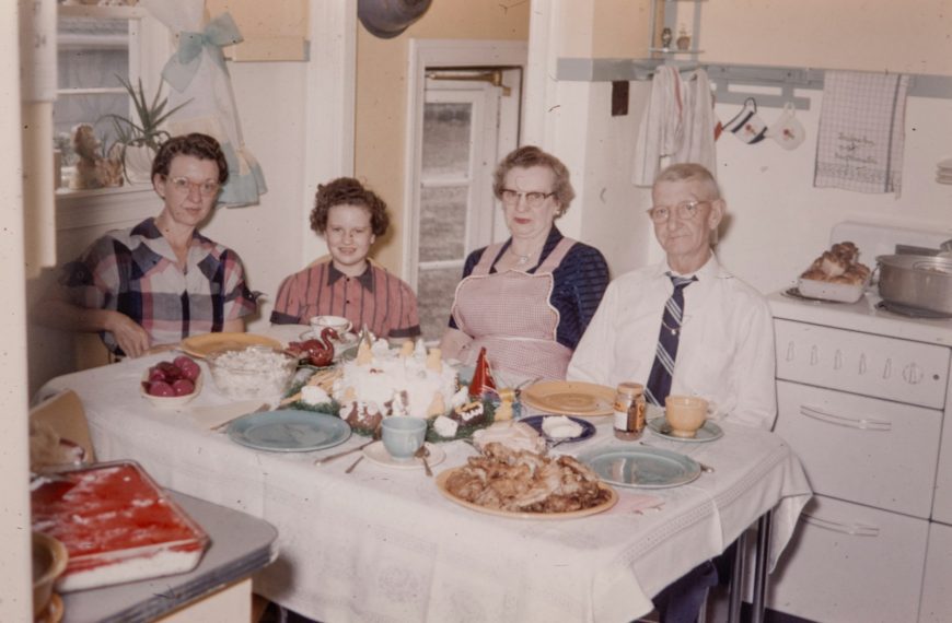 a group of people sitting around a table with food on it