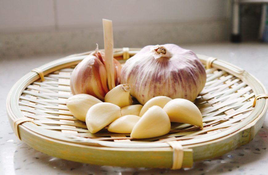 a basket of garlic and garlic bulbs on a counter