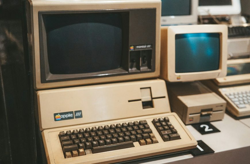 a row of old computers sitting on top of a desk