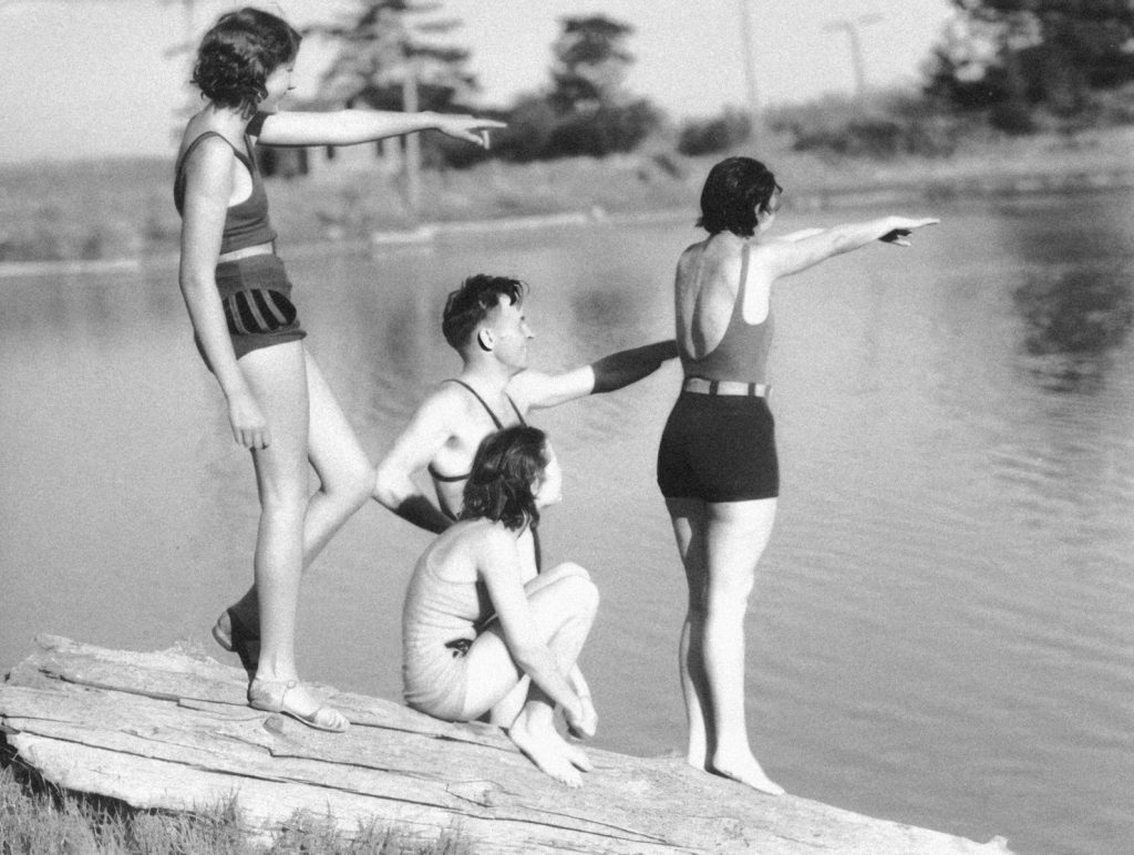 a black and white photo of a group of people on a dock