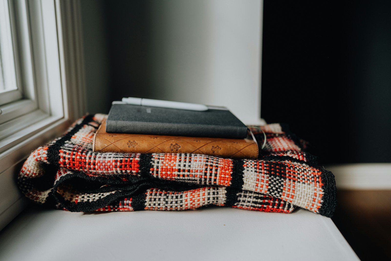 A stack of books sitting on top of a white couch