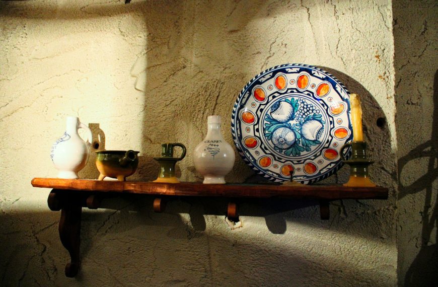 a shelf with vases and a plate on it