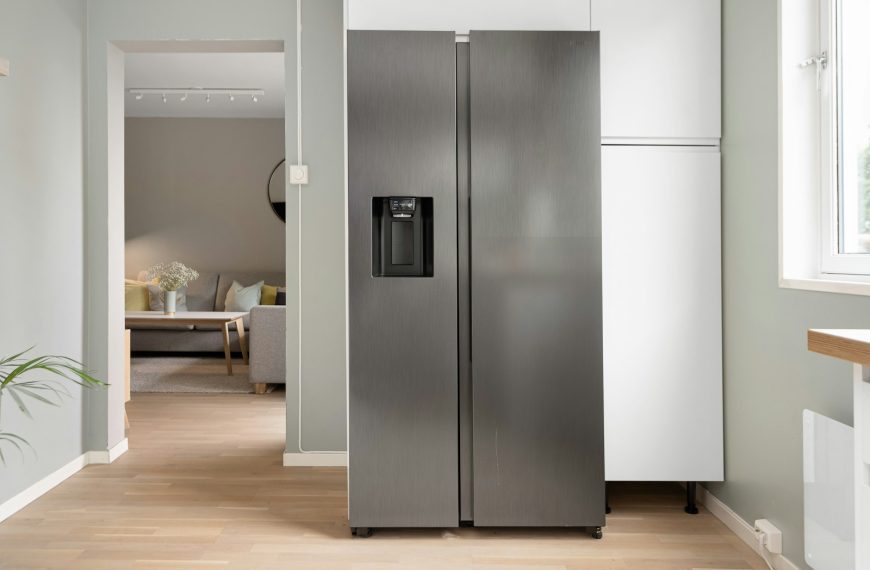 A refrigerator in a kitchen next to a window